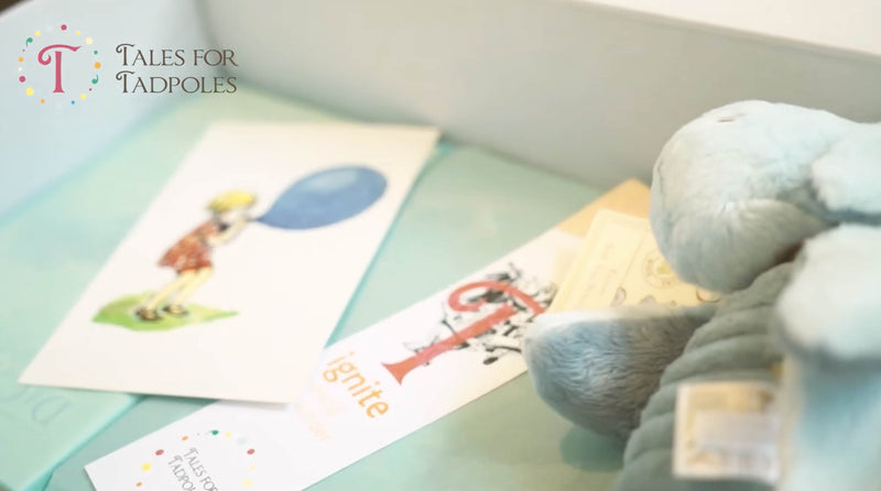 A close up shot of a gift box wonderbox with a print, bookmark and cuddly toy